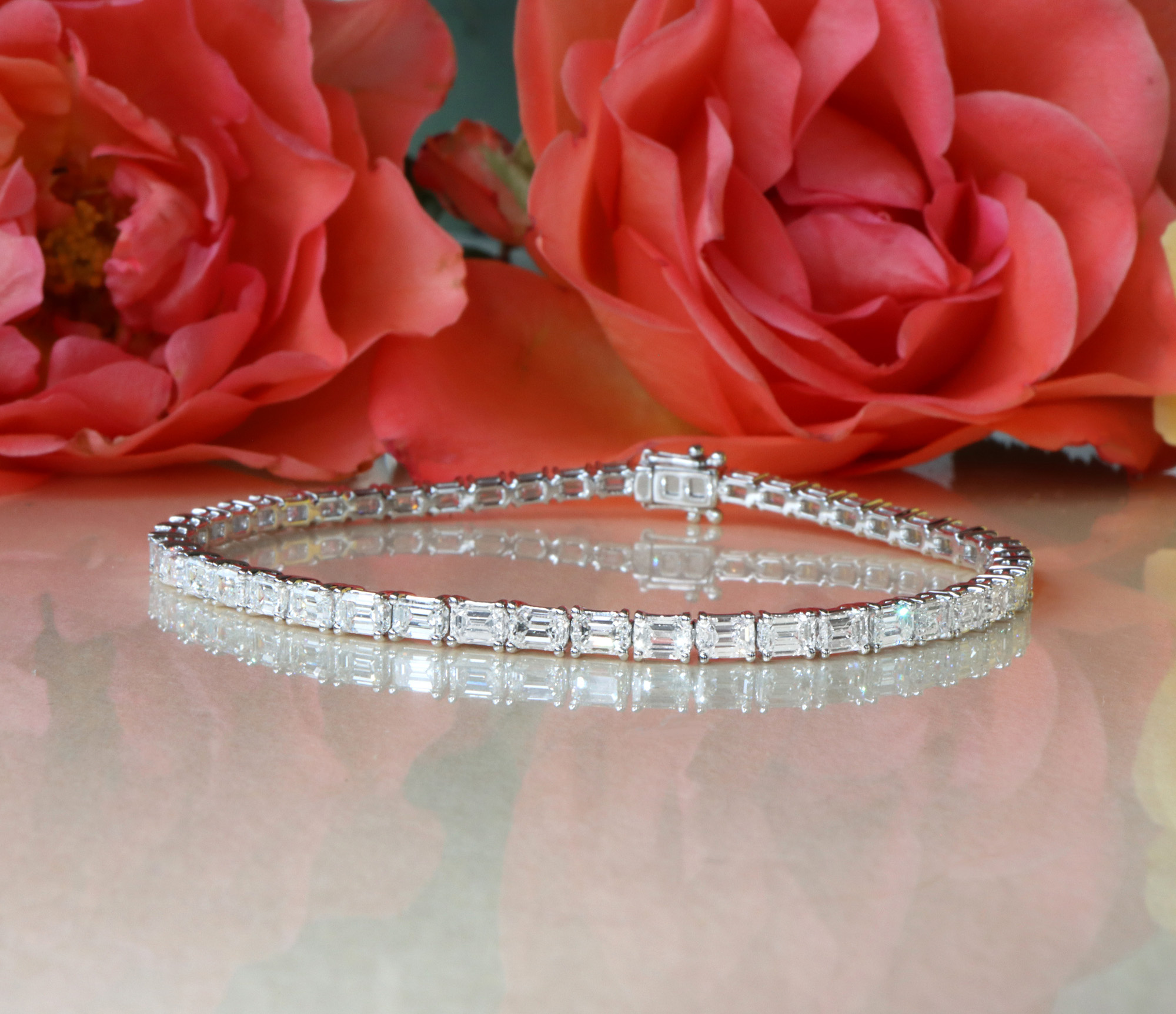 Smaragdschliff-Diamanten-Tennisarmband auf Rosenblättern, Detailaufnahme