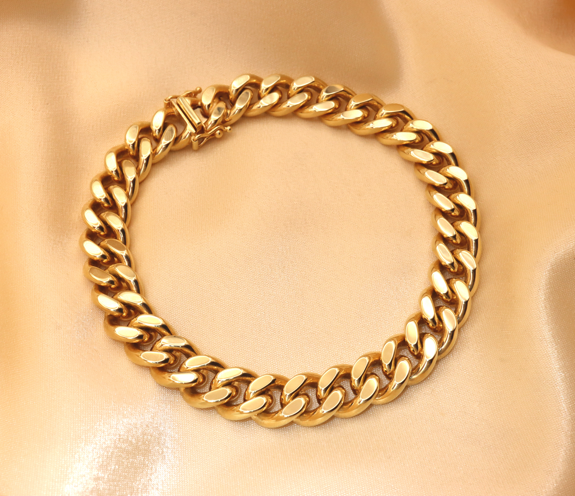 Gold Panzerarmband in 585er Gelbgold, detailreich, großzügig, auf cremefarbenem Stoff liegend.