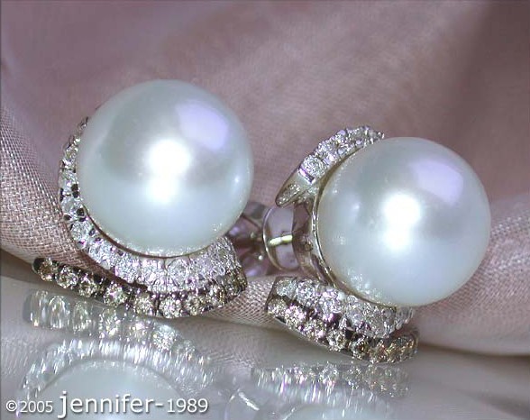 Perlenohrringe mit Diamanten auf weichem Stoff