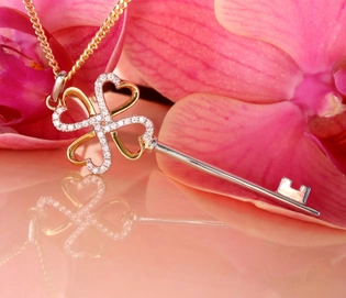 Goldener Schlüsselanhänger mit Brillanten auf rosa Orchidee, Detailaufnahme.