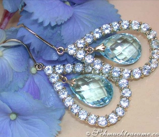 Blautopas-Ohrhänger mit Gelbgold 585, umgeben von blauen Blütenblättern