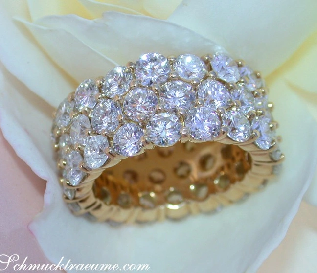 Gelbgoldring mit Brillanten in drei Reihen, Detailaufnahme, weißer Blütenhintergrund Gelbgoldring mit Brillanten in drei Reihen, Detailaufnahme, weißer Blütenhintergrund