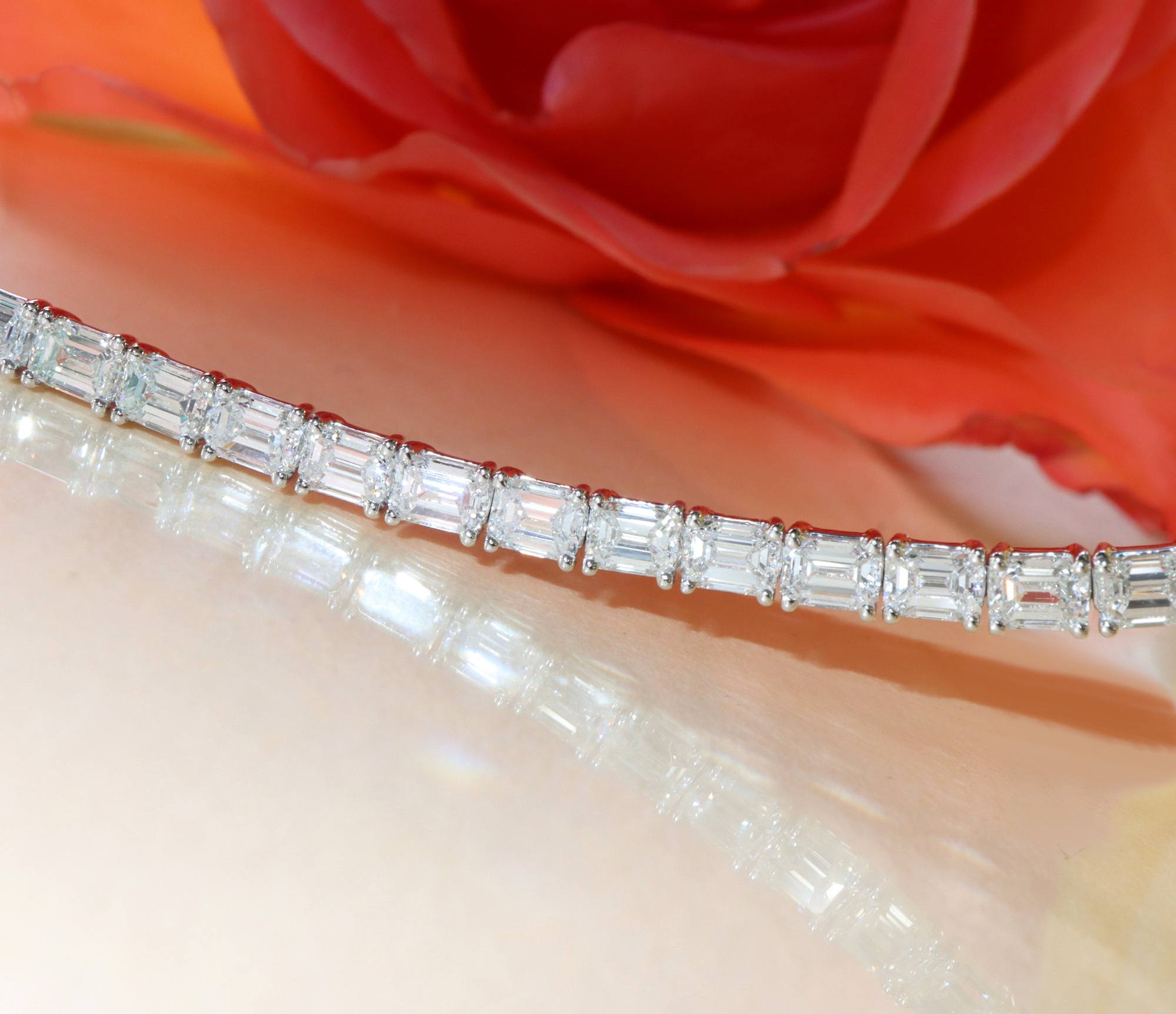 Exquisites Tennisarmband mit Smaragd-Schliff-Diamanten, Detailaufnahme auf Rosenblatt