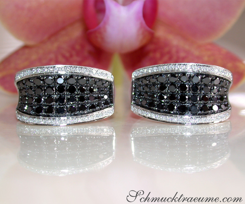 Schwarz-weiße Diamantohrringe auf Orchideenhintergrund