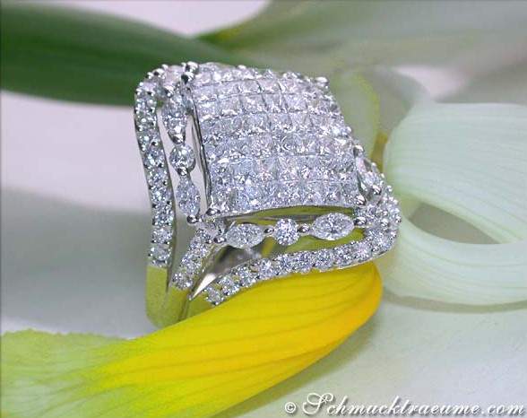 Diamantring mit Princess-, Marquise- und Brillantschliff auf Blume liegend
