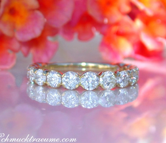 Goldener Erlesener Brillanten Memory Ring mit feinen Diamanten auf Blütenhintergrund Goldener Erlesener Brillanten Memory Ring mit feinen Diamanten auf Blütenhintergrund