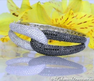 Schwarz-weiß Diamant-Armreif aus Weißgold, Detailaufnahme mit gelber Blume im Hintergrund.