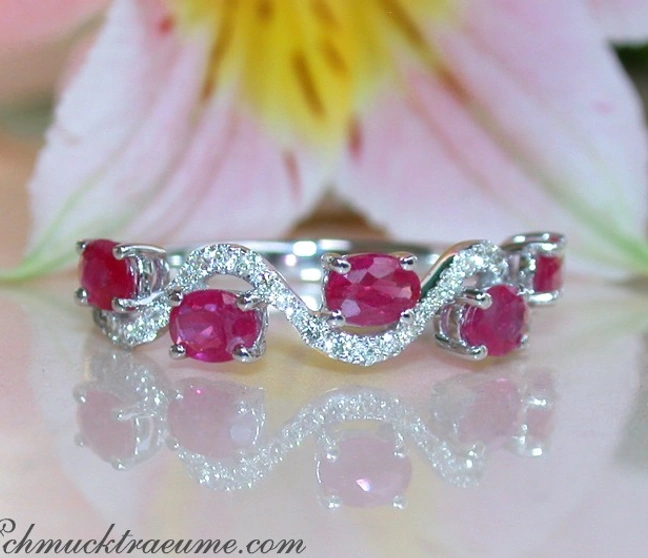 Weißgold-Ring mit ovalen Rubinen und runden Diamanten, Blume im Hintergrund Weißgold-Ring mit ovalen Rubinen und runden Diamanten, Blume im Hintergrund