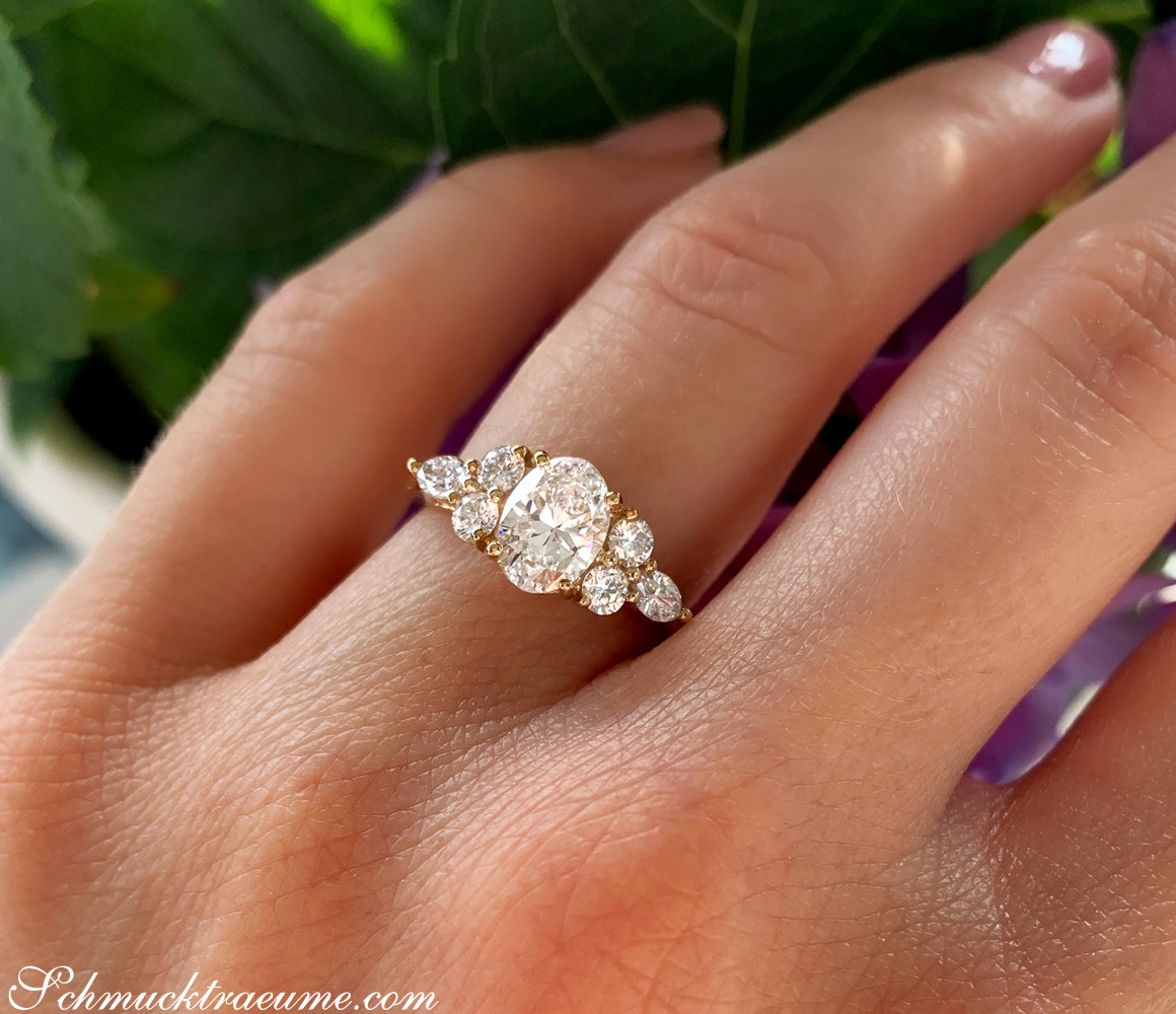 Runder Diamant im Ovalschliff auf Goldring, umgeben von Marquise-Diamanten