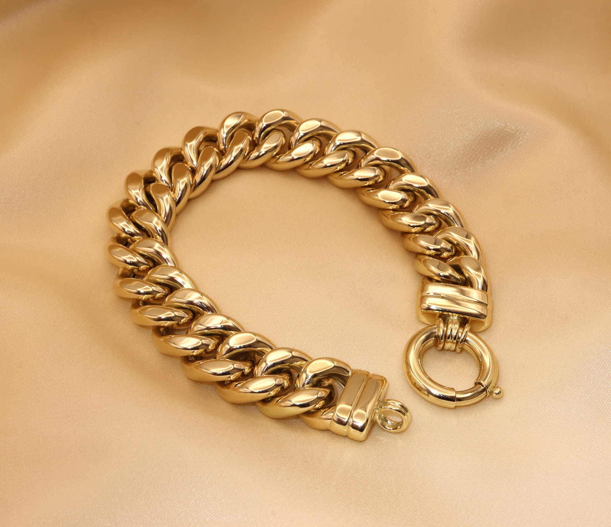 Gold Panzerarmband in Gelbgold 585, 60 Gramm, detailreich, geschwungen, elegant auf goldfarbenem Stoff liegend