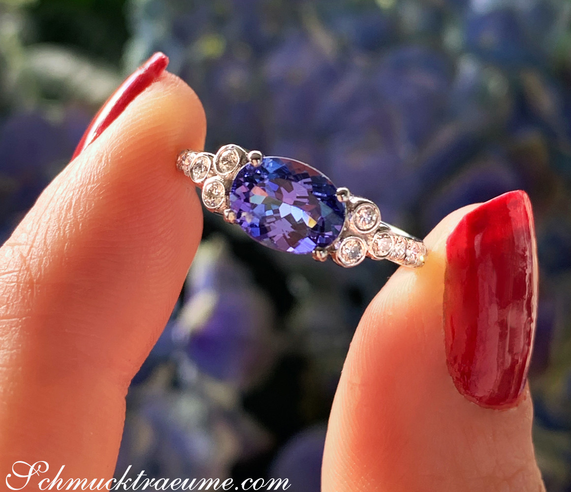 Raffinierter Tansanit-Ring mit Brillanten auf Fingern mit rotem Nagellack