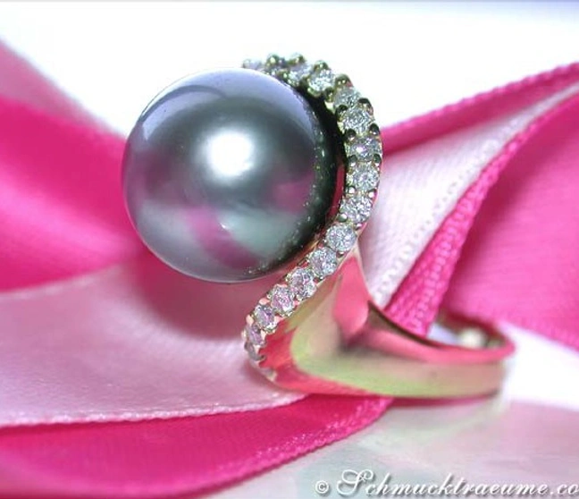 Schlichter Tahitiperlenring mit Brillanten in Gelbgold auf pinkem Stoff Schlichter Tahitiperlenring mit Brillanten in Gelbgold auf pinkem Stoff