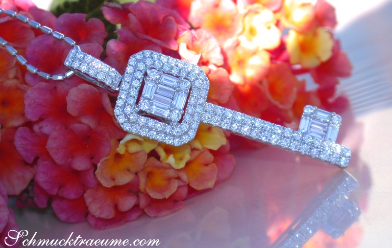 Schlüsselanhänger aus Weißgold mit Brillanten & Baguettes, Detailaufnahme auf Blütenhintergrund