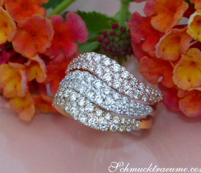 Blumiger Hintergrund mit drei eleganten Brillant-Ringen aus Gelb-, Rosé- & Weißgold 750 Blumiger Hintergrund mit drei eleganten Brillant-Ringen aus Gelb-, Rosé- & Weißgold 750