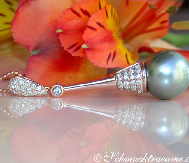 Extravagantes Tahitiperlen-Anhänger mit Brillanten in Roségold, detailreich mit Perlen und Diamanten, auf blühendem Extravagantes Tahitiperlen-Anhänger mit Brillanten in Roségold, detailreich mit Perlen und Diamanten, auf blühendem