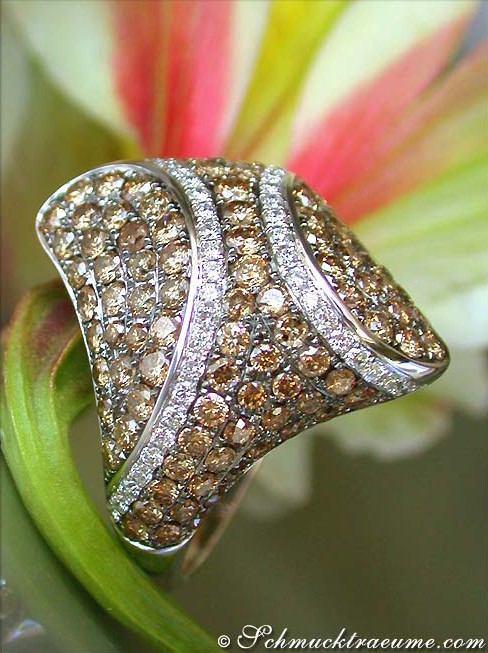 Detailansicht von Ring mit naturbraunen und weißen Brillanten auf Blüte.