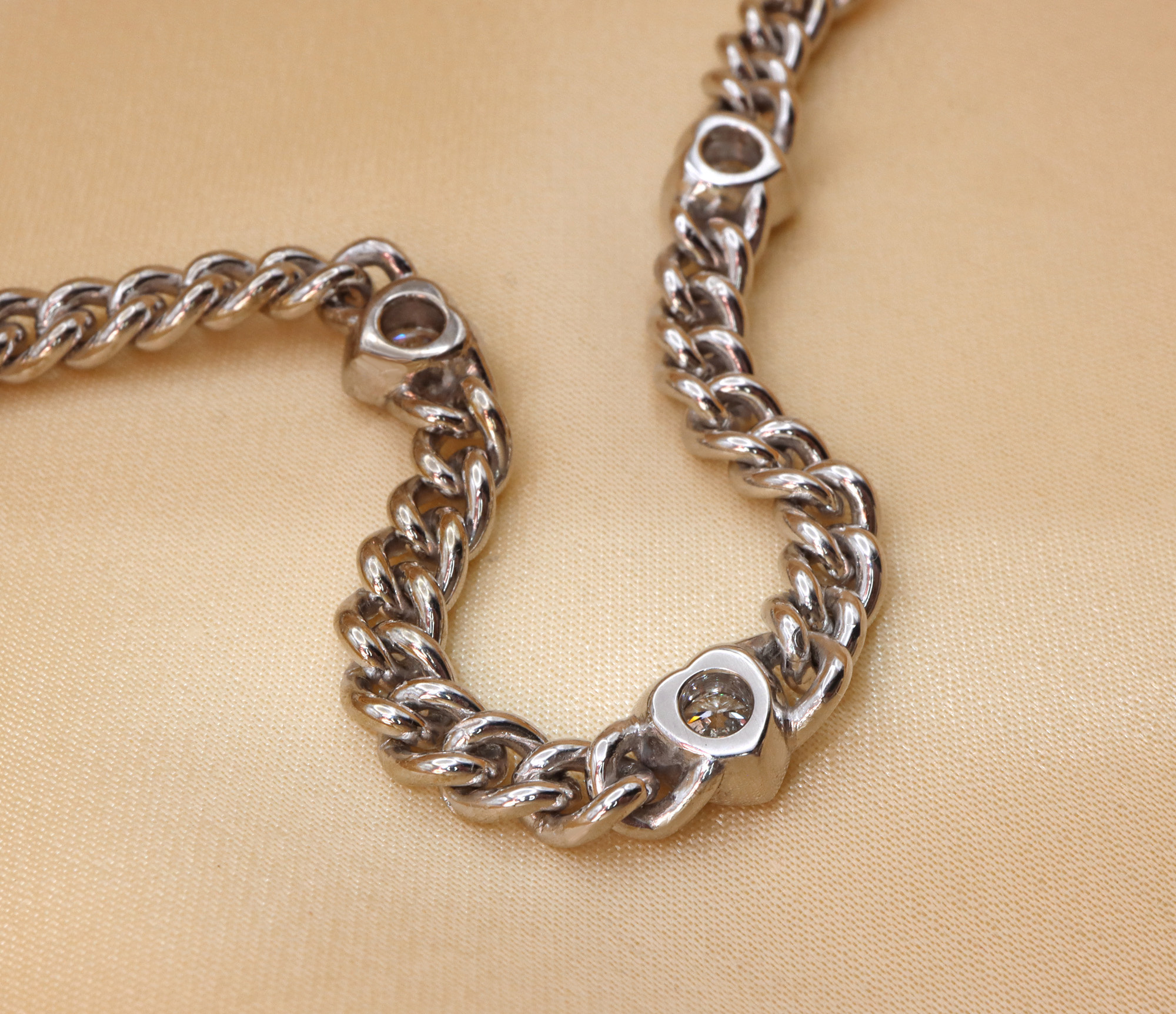 Silbernes Panzerarmband mit Brillantenherz, Detailaufnahme, geschwungene Kettenstruktur