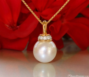 Goldkette mit Perlenanhänger und Brillanten, makellose Perle, rote Blüte im Hintergrund