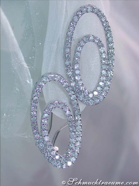 Verzierte Brillanten-Ohrringe im Ellipsen-Design auf transparenter Stoffoberfläche