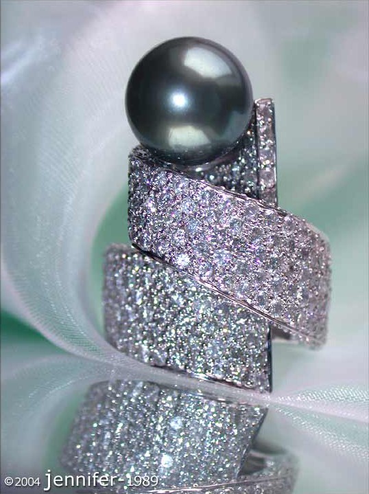 Detailaufnahme des eleganten Tahitiperlen-Rings mit Brillanten in Weißgold, auf weißem Tuch.