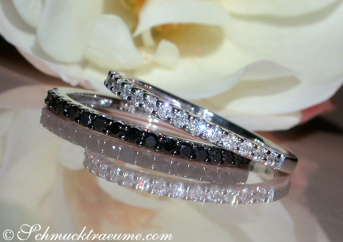 Schwarz-weiße Diamantring-Set mit Blume im Hintergrund