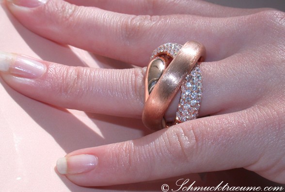 Roségold-Ring mit überkreuzten Brillanten, Detailaufnahme auf Handfinger.