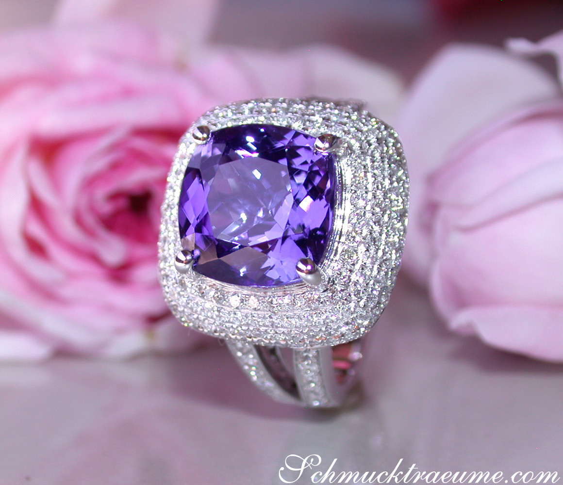 Weißgold-Tansanit-Ring mit Brillanten im Carré-Design auf Rosenblüte.