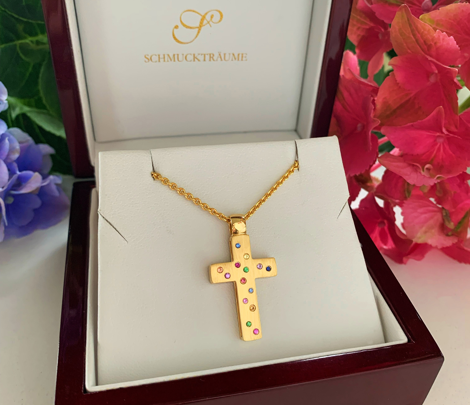 Goldener Kreuzanhänger mit Brillanten und Multicolor Saphiren, präsentiert in Luxusverpackung.