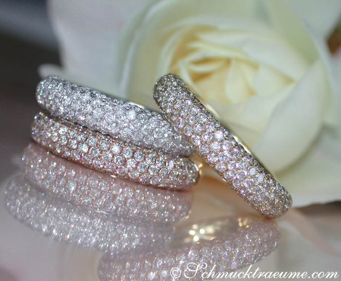 Weißgold-Diamant-Pavé-Ring mit Rosenblüte im Hintergrund