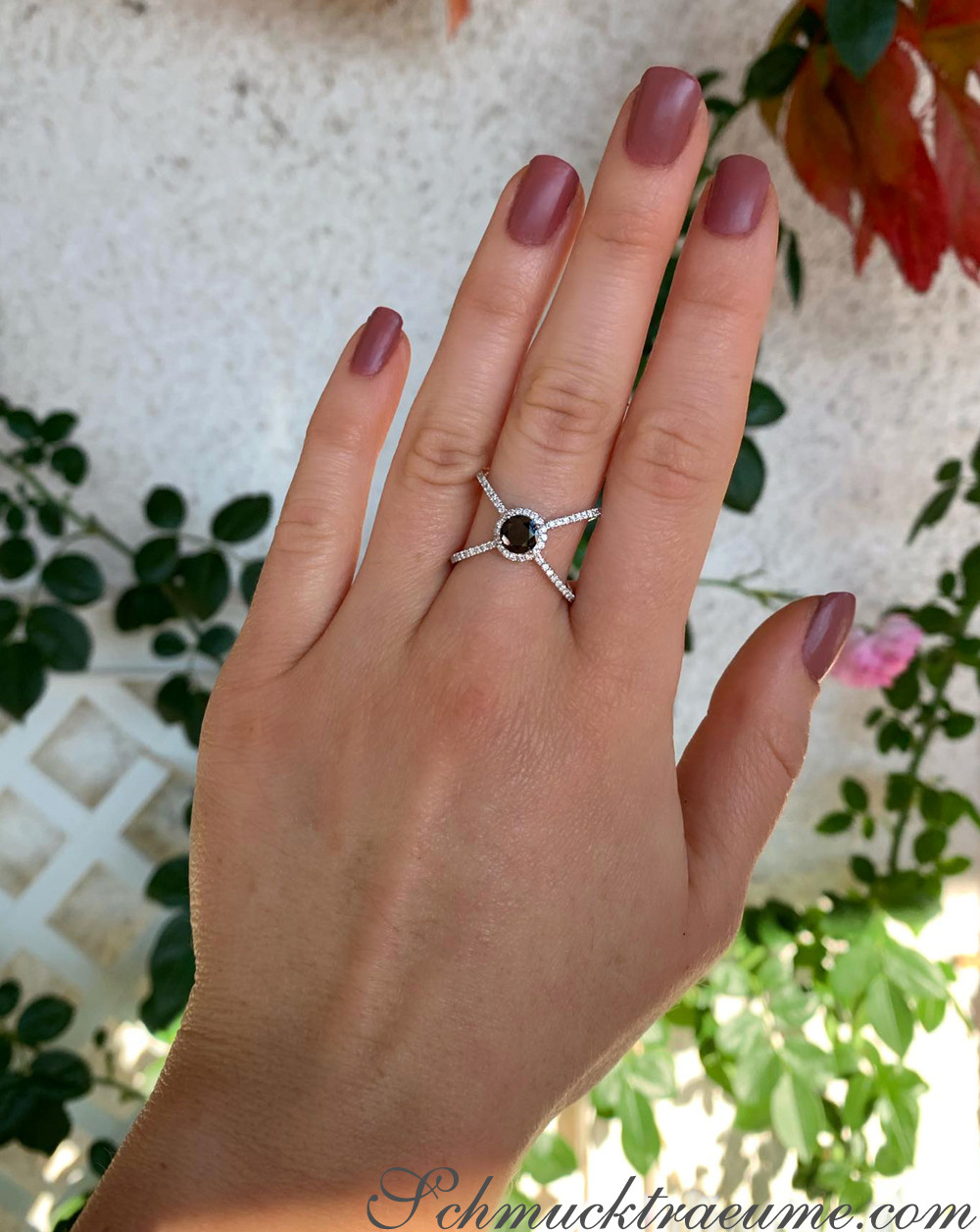 Schwarzer Diamant Solitär-Ring auf Hand vor Blättern