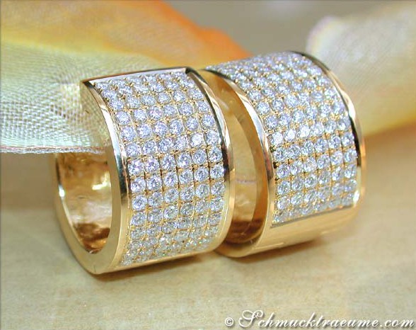 Goldene Creolen mit Diamanten auf elegantem Hintergrund