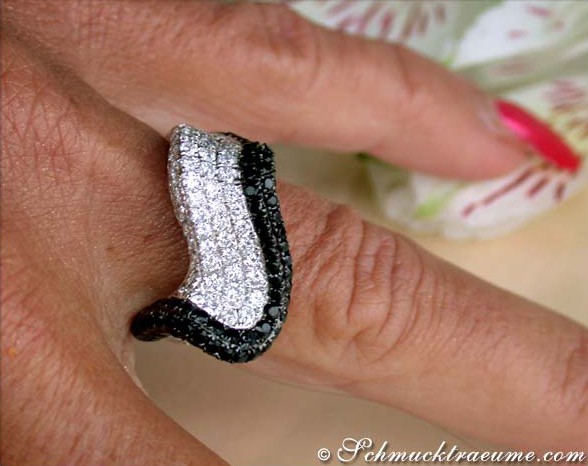 Weiches Wellendesign, schwarz-weiße Diamanten, Detailaufnahme auf Finger, elegant.