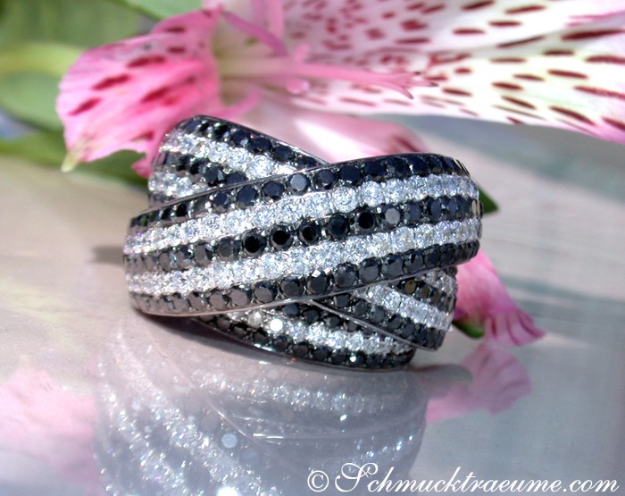 Schwarz-Weiß-Diamant-Ring mit Kreuzverlauf auf glänzendem Hintergrund