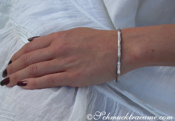 Weißgold-Armreif im Bambus-Design, Diamanten, Detailaufnahme, elegant, handgestrickter Stoffhintergrund