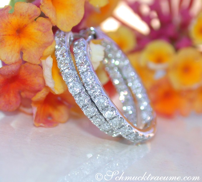 Weißgold 585 Creolen mit Brillanten, Detailaufnahme, Blumen im Hintergrund