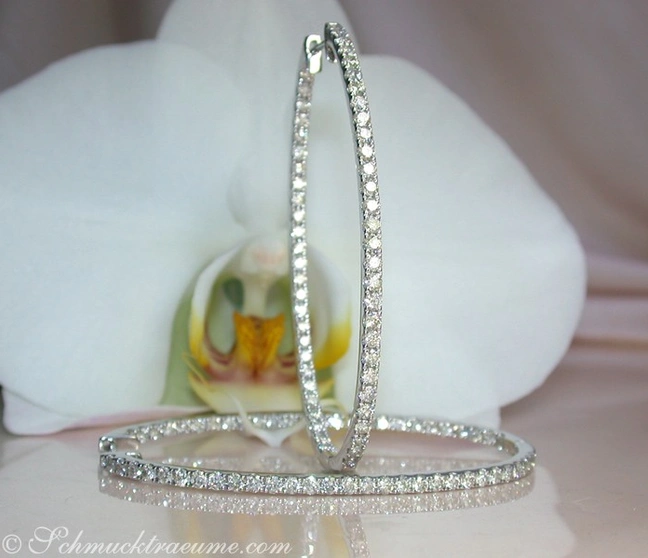 Ovale Creolen aus Weißgold mit Brillanten, elegant auf Orchidee präsentiert. Ovale Creolen aus Weißgold mit Brillanten, elegant auf Orchidee präsentiert.