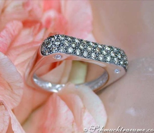 Weißgold-Ring mit naturbraunen Diamanten auf rosafarbenem Blütenhintergrund