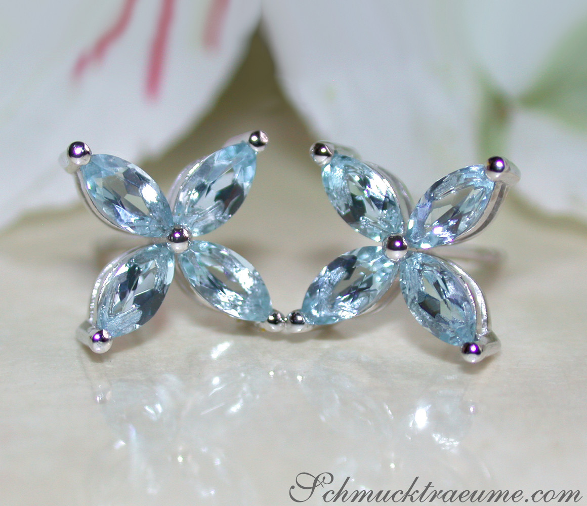 Weißgold-Ohrringe mit blauen Aquamarin-Steinen in Blütenform, zarte Eleganz.