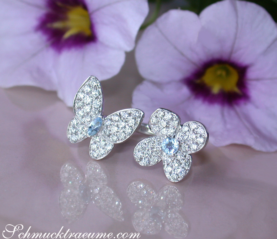 Flora: Blumenblüten im Hintergrund, brillant besetzte Schmetterlingsringe, weiches Licht, detailreiche Schmuckstücke.