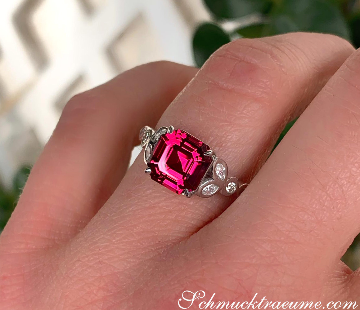 Weißgold-Ring mit himbeerrotem Rhodolith und Diamanten, Detailaufnahme, tragen auf Finger.