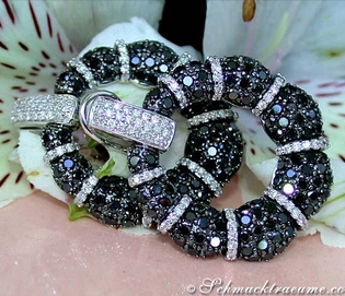 Schwarz-weiß Diamant-Armband mit Herzverschluss auf Blume liegend