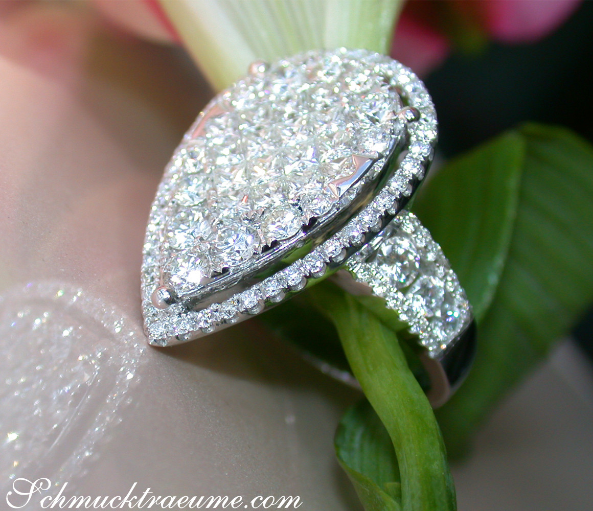 Weißgoldring mit Diamanten im Princess- & Brillantschliff, Detailaufnahme, getragen auf Hand.