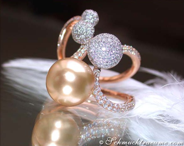 Goldener Perlenring mit Pave-Brillanten auf Federhintergrund