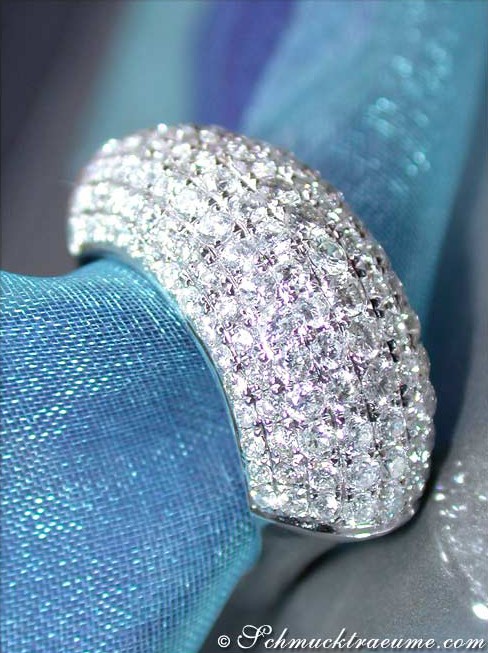 Detailaufnahme eines Diamantenpavé-Rings in Weißgold 750, glitzernd auf blauem Stoff