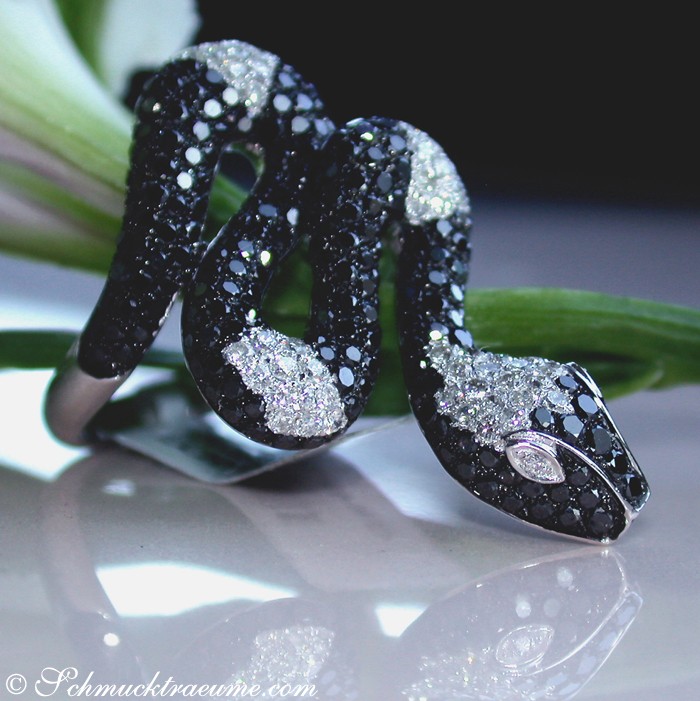 Schlangenring mit schwarzen Diamanten, detailreich verziert, weißgold 585, auf glänzender Oberfläche präsentiert.