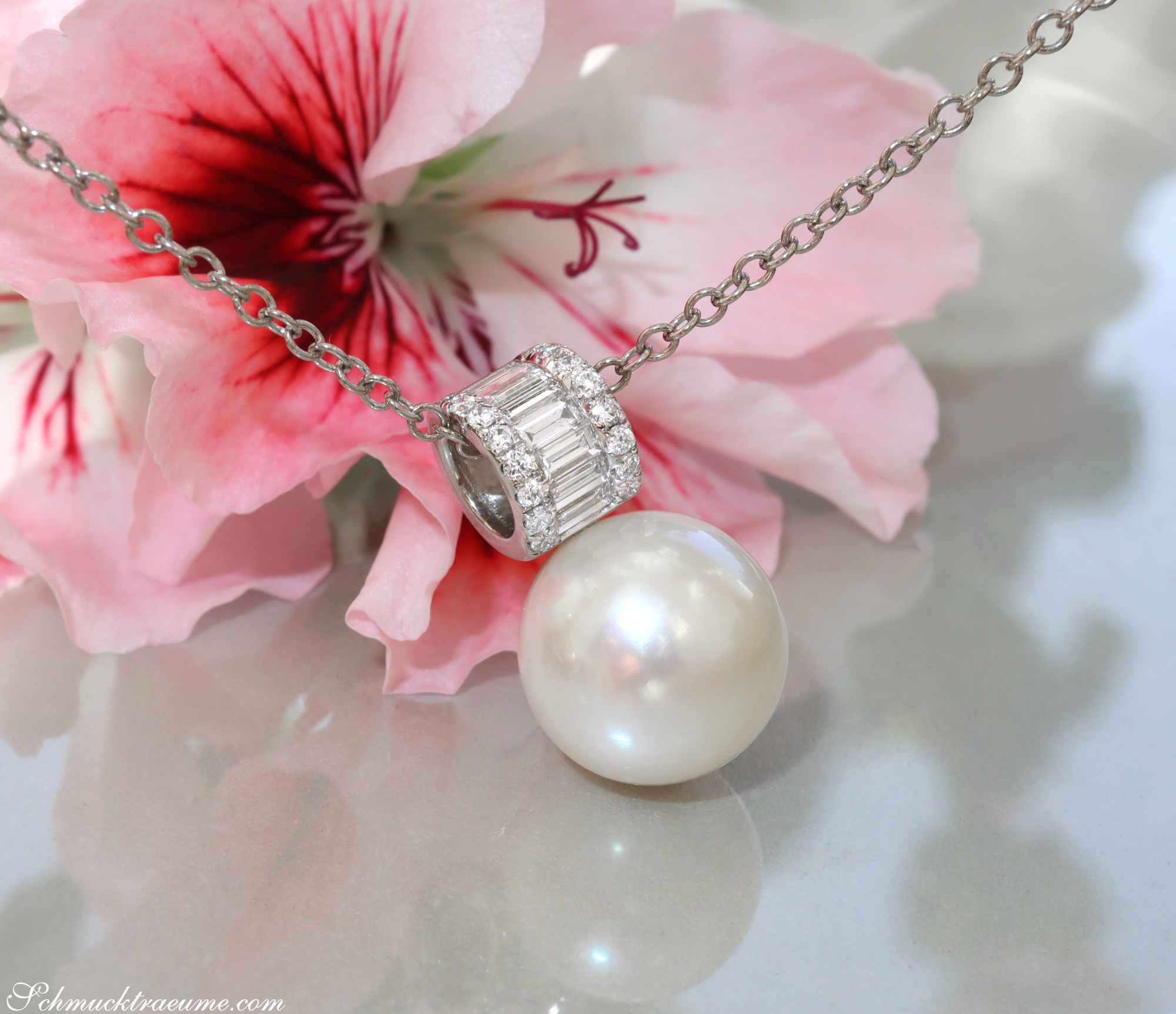 Perlenanhänger mit Baguette-Diamanten auf Kette, Blume im Hintergrund