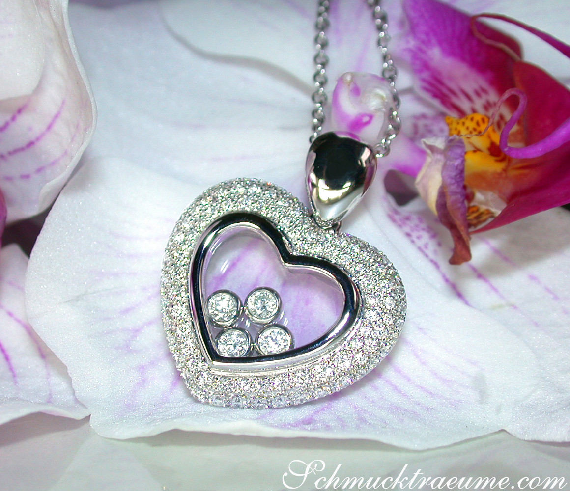 Herz-Anhänger mit Brillanten und Perlen, umgeben von Orchideenblüten.