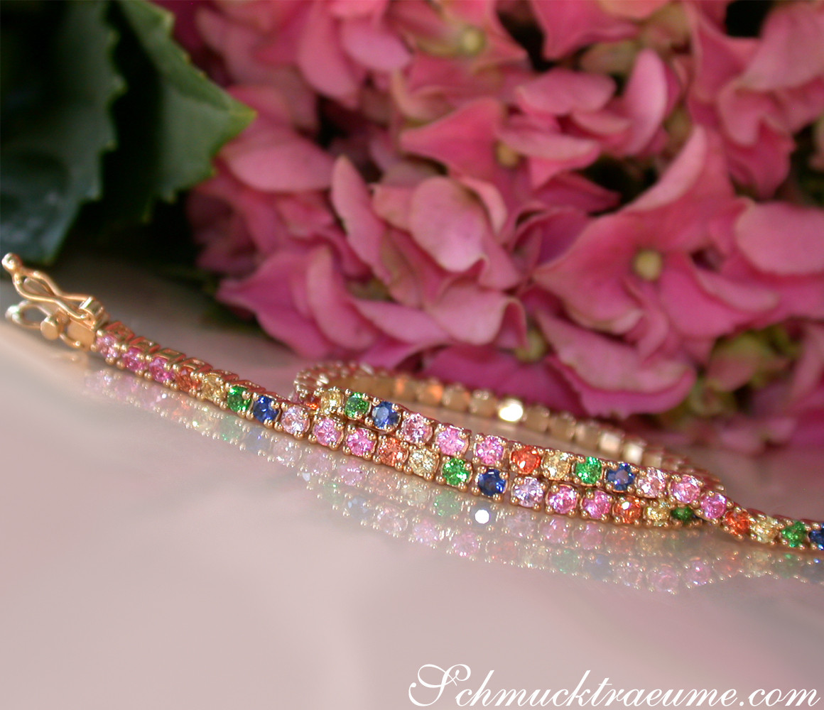 Goldenes Multicolor Saphir Tennisarmband vor rosa Hortensienblüten.