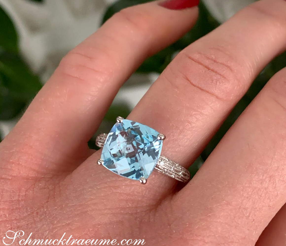 Blautopas-Ring mit Diamanten auf Handfinger, Detailaufnahme.