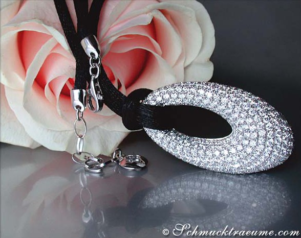 Detailansicht des Brillanten Donut Anhängers mit Kordel und Blume im Hintergrund